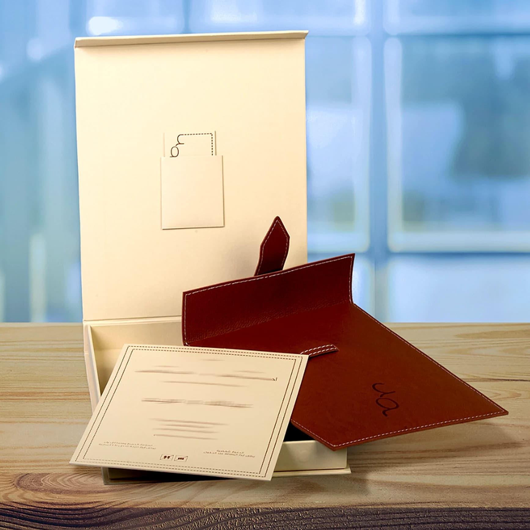 Cream invitation box with a stitched leather envelope and a printed card